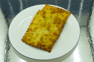 Chebureks pişirme süreci. Beyaz ve Doğu doldurulmuş kuzu ve baharatlı çeşnilikler ile ince mayasız hamur yapılmış bir patty besindir. Cheburek - kızarmış pasta etli ve