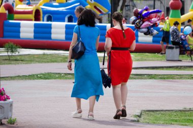 Güneşin doğuşunda, arka planda sıcak bir ışıkla parkta birlikte yürüyen iki arkadaşın arka planı.