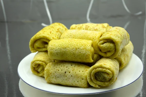 Fried spring rolls on black slate plate on grey stone slate background. Top view