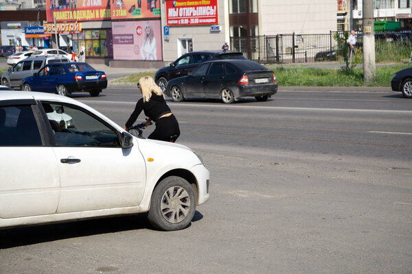 street with cyclists and cafes. there are about bicycles. Focus on the cyclists in the foreground. Russia Berezniki 27 July 2017 .