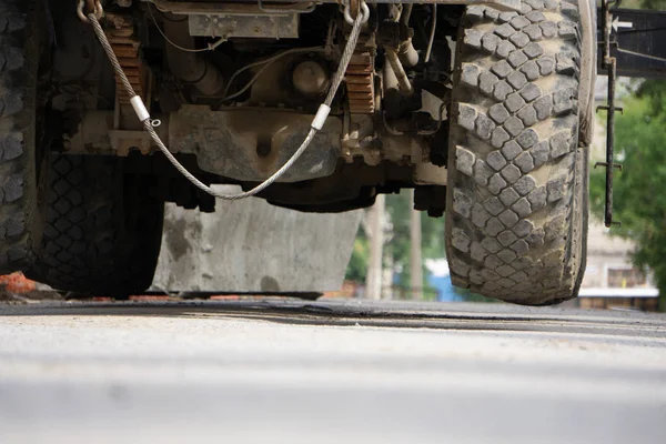 都会で晴れた日、近づいてくる車のヘッドライト、車の車輪からの道路レベルからの眺め . — ストック写真