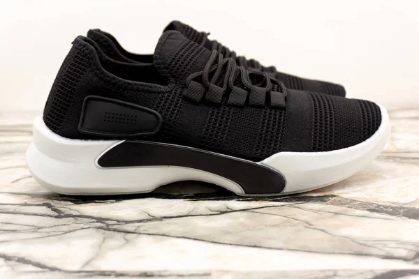 Sneakers sportive unisex nere con suola bianca e lacci bianchi su sfondo bianco  . — Foto Stock