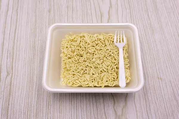 Egy tányéron lévő Instant tészta fekete háttérrel. Gyorsétterem, gyorsétel, egészségtelen étel. A a. rolton Doshirak — Stock Fotó