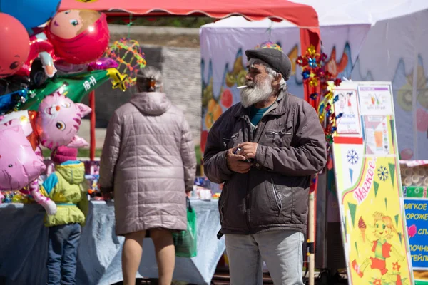 Family with children purchasing traditional Caga Tio toys at fair. Focus on blonde girl . Russia Berezniki 26 may 2019 — Stock Photo, Image