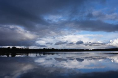 Aydınlatılmış tepeleri olan yüksek dağları olan güzel bir manzara, dağ gölündeki taşlar, yansıma, mavi gökyüzü ve gün doğumunda sarı güneş ışığı. Nepal 'de. Himalaya dağlarıyla muhteşem bir manzara. Himalayalar .