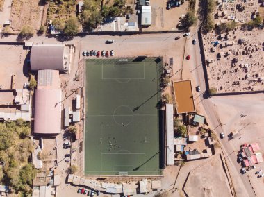 Football field located in a very poor and dry city looked from the air clipart