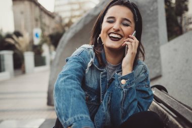 Serin ve güzel genç kadın şehirde telefonda konuşma. Kentsel tarzı