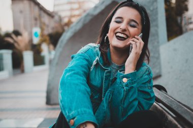 Serin ve güzel genç kadın şehirde telefonda konuşma. Kentsel tarzı