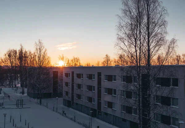 Солнце встает в пригороде за панельными домами зимним утром — стоковое фото