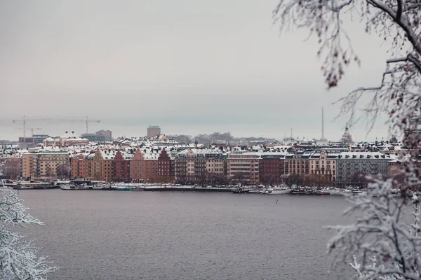 Gamla byggnader vid floden en fuktig vinterdag med snö och dimma, Stockholm Sverige — Stockfoto