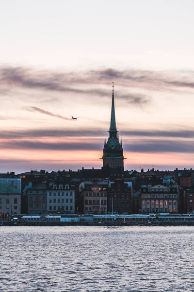 Vista da cidade velha com um avião voando como o sol está se pondo, Estocolmo Suécia — Fotografia de Stock