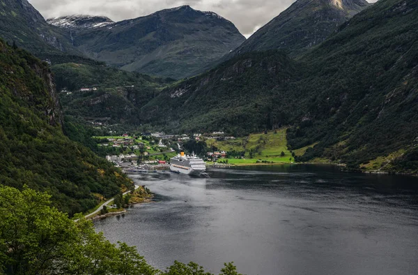 夏天的一天 人们从山坡上看到Geiranger Fjord 他的一艘游轮停泊在港口 身后是挪威的高山 — 图库照片