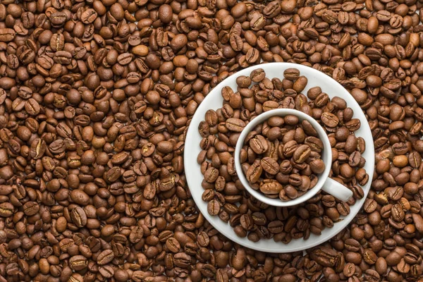 Kahve fincanı ve tabağı kahve taneleri ile doldurulur 