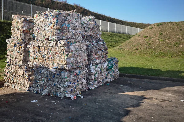 Modern waste sorting and recycling plant. Bales of dairy and drink bottles garbage in recycling plant yard prepared for shipment and reuse. Concept of recycling materials and environmental protection.