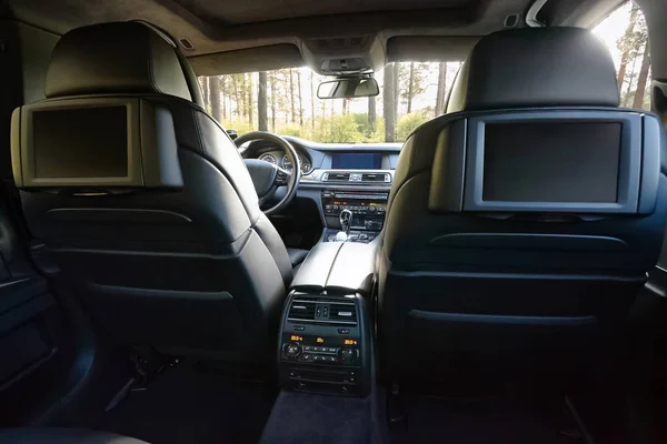 Car inside. Interior of prestige luxury modern car. Three TV displays for passenger with media control panel copy space and mock up.