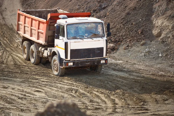 Heavy multi-ton mining truck exporting minerals from open-pit mine. Concept of shipping and protecting the environment and nature.