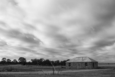 Eski göztaşı bina ve fırtına bulutları siyah ve beyaz