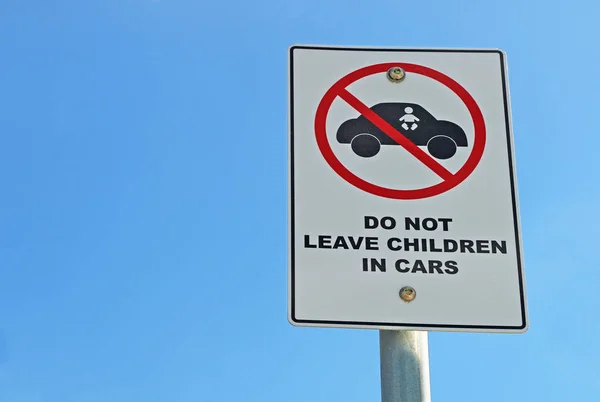 red, black and white Do Not Leave Children In Cars sign in a blue sky