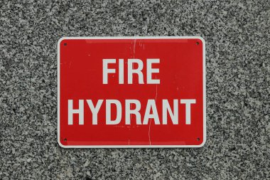 Granit duvar arka plan üzerinde kırmızı ve beyaz yangın hidrant işareti