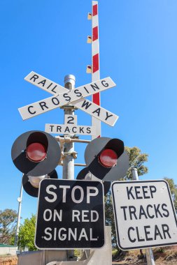 siyah, beyaz ve kırmızı tren kapısı uyarı işaretleri, ışıklar ve boom gates de mavi bir gökyüzü
