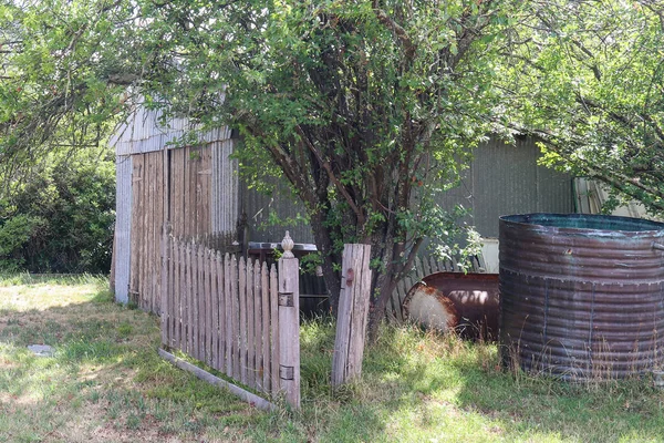 Doors on an iron shed and an old wooden picket fence in a rural setting — Stock Photo, Image