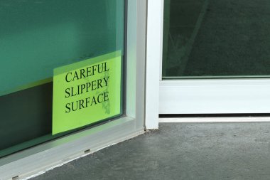 Bir binanın girişine yakın dikkatli Kaygan yüzey işareti