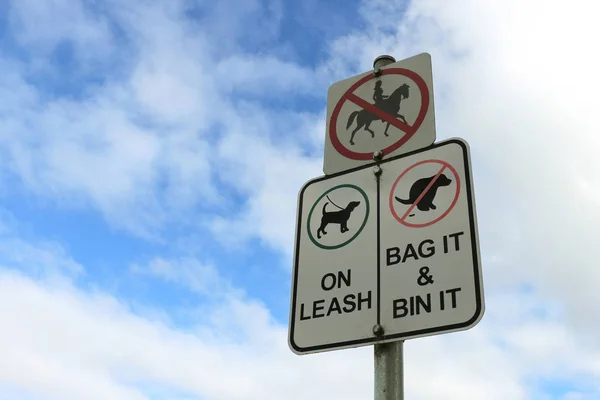 Cani al guinzaglio, Bin it bag, e nessun cavallo ammessi segni nel cielo blu — Foto Stock