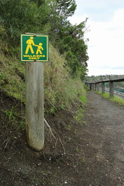 Yellow and green Walkers Only sign on a narrow track — Stock Photo, Image