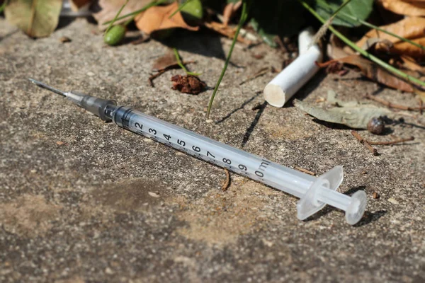 Used and discarded syringe on the street Royalty Free Stock Photos
