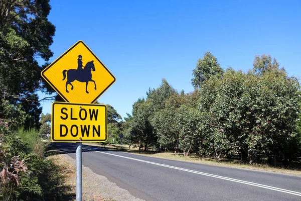 siyah ve sarı Slow Down, At Biniciler ikaz işareti yolun bir streç yakınında