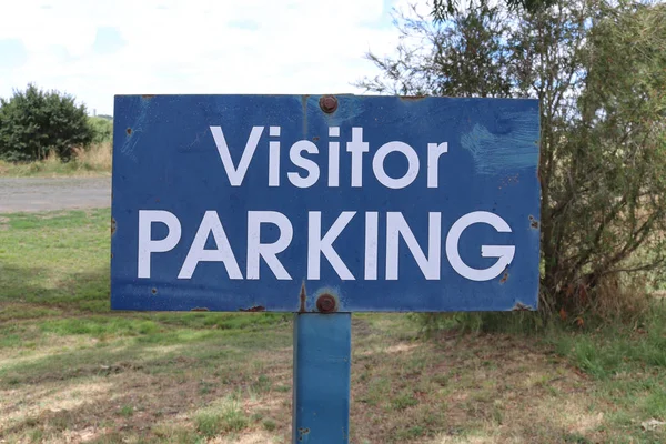 Un metallo intemperie blu e bianco Visitatore Parcheggio segno — Foto Stock