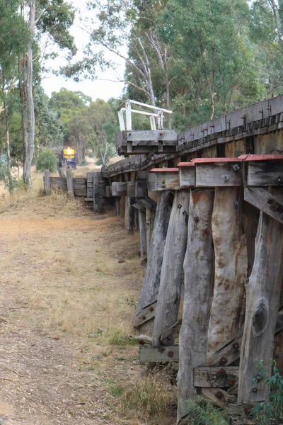 Muckleford, Australia-18 lutego, 2018: niebieskie i złote dziedzictwo wiktoriańskie koleje klasy Y silnik Diesla zbliża się zabytkowy drewniany most w pobliżu Muckleford dworca kolejowego — Zdjęcie stockowe