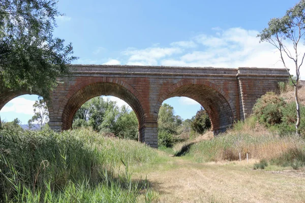 HARCOURT, AUSTRALIA - 25 febbraio 2018: il viadotto ferroviario (1859) sopra Barkers Creek è costruito in granito Harcourt e comprende tre archi principali — Foto Stock