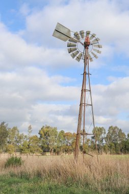 Avustralya kırsalında bulutlu bir gökyüzünde yel değirmeni