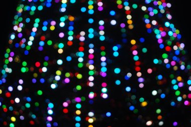 Yılbaşı ağacının arka planından, gece gökyüzüne doğru odaklanmış bir parıltı, neşeli bir arka plan..