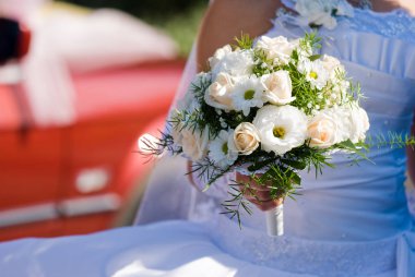 Düğünde gelinin elinde bir buket çiçek.