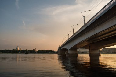 Yaz akşamında nehir ve köprünün üstünde gün batımı