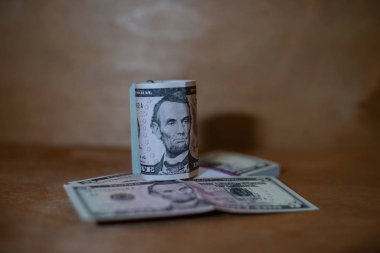 Beş dolar faturaları banknot bir paket üzerinde yalan bir rulo.
