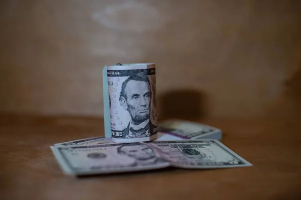 紙幣の束の上に横たわるロールの 5 ドル紙幣. ロイヤリティフリーのストック画像