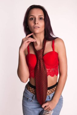 Güzel kız bir kırmızı kravat ve kırmızı top. Genç esmer kız.