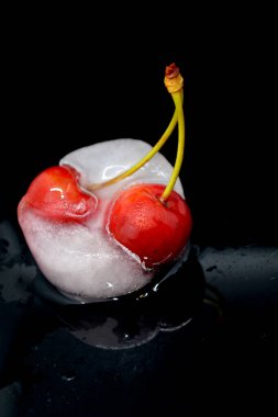 Siyah arkaplanda donmuş kırmızı kiraz meyvesi