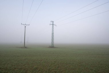 Sis alanında iki elektrik direkleri