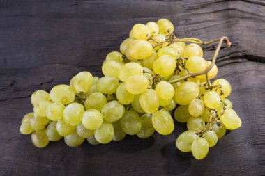 Sarı friut üzüm koyu ahşap üzerine oturuyor