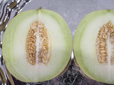 Taze sarı kavun içinde closeup eski tepsi üzerinde ikiye böldüm