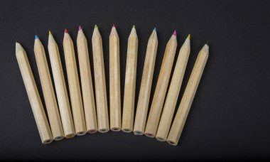 Okula geri ve siyah arka plan üzerinde renkli kalemler üzerinde portre sınıf malzemelerle karıştırın