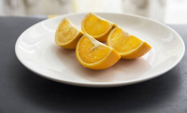 Orange cut in to slices on the white plate
