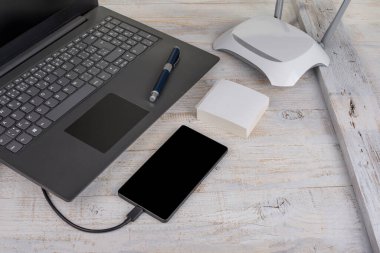 Modern dizüstü bilgisayar, ahşap kablosu olan akıllı telefon.
