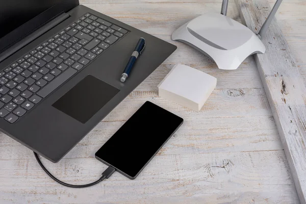 Modern dizüstü bilgisayar, ahşap kablosu olan akıllı telefon.