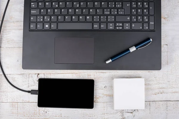 Modern dizüstü bilgisayar, ahşap kablosu olan akıllı telefon.