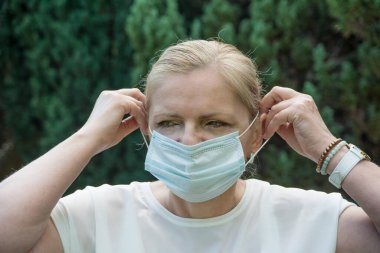 Gözlüklü ve maske takan olgun bir kadın. Coronavirus koruması